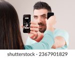 Small photo of Forgoing conversation, a man and woman show screens to each other, sharing internet content rather than personal thoughts, echoing ancestors showing items and nodding, bypassing true communication and