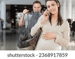 Small photo of Husband carries bags, following his pregnant wife as she talks on the phone, oblivious. Highlighting the idea of maternity and a dysfunctional relationship