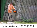 A Man Is Cutting A Thick Trunk...