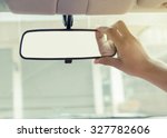 Hand adjusting rear view mirror.