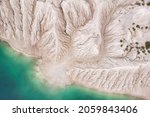 Small photo of Amazing kaoline quarry, texture of kaolin quarry, abstract patern of kaolin and beautiful water, aerial view of industrial clay hills, environment after mining, industrial lifeless desert