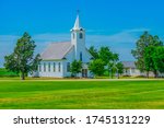 A Steepled White Church Sits In ...