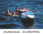 Small photo of Group of young sup surfers fall from SUP stand up paddle board, women drowning, concept of fail solving problems, team work and survival, boat accident during stand up paddling, standup paddleboarding