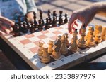Small photo of Chess tournament, kids and adults participate in chess match game outdoors in a summer sunny day, players of all ages play, competition in chess school club with chessboards on a table