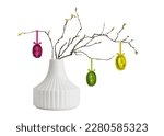 Ceramic vase and spring twigs with Easter eggs isolated on white background. Springtime interior decoration. 