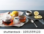 Small photo of black Bayh tea with lemon in glass teapot and glass tea mug