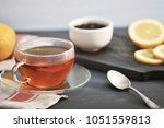 Small photo of black Bayh tea with lemon in glass teapot and glass tea mug