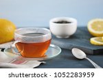 Small photo of black Bayh tea with lemon in glass teapot and glass tea mug