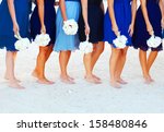 A bride and her bridesmaids holding flowers at beach in Key West Florida