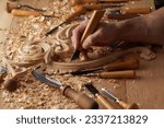 Small photo of Woodwork and Wood carving. Carpenter's hands use chiesel. Senior wood carving professional during work. Man working with woodcarving instruments