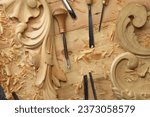 Small photo of Hands of craftsman carve with a gouge in the hands on the workbench in carpentry. Wood carving tools close-up top view.
