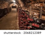 Small photo of Ancient dusty wine bottles in an old cellar. Expensive wine in the historic cellar. Old wine bottles in rows in the wine cellar.