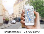 Tourist using GPS map navigation app on smartphone screen to get direction to destination address in the city streets, travel and technology