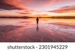 Small photo of Person standing in salt lake during colorful sunset, epic mood beautiful travel photo