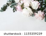 Styled stock photo. Decorative still life floral composition. Wedding or birthday bouquet of pink and white peony flowers and eucalyptus branches. White table background. Flat lay, top view.