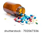 Pills spilling out of pill bottle on white background