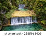 Waterfall cascades on the Pisnica river, Kranjska Gora, Slovenia, Triglav National Park. Autumn landscape with falling water surrounded by wooded cliffs, outdoor travel background