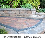 Small photo of Footpath with step backed by block retaining wall and paver walkway part of garden landscape design background