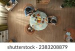 Small photo of Top view of family sitting at the table eating breakfast, father looks at mother who is busy with smartphone, ignoring everyone.