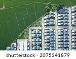Small photo of Land or landscape of green field in aerial view. Include agriculture farm, house building, village. That real estate or property. Plot of land to housing subdivision, development, sale or investment.