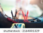 Small photo of Charging electric power, energy to accumulator or dead battery in breakdown motorcycle for start. Include equipment tool i.e. portable trickle charger, positive negative clamp, red black cable wire.