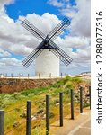 Small photo of Wind mill at knolls at Consuegra, Toledo region, Castilla La Mancha, Spain. Route of Don Quixote with windmills. Summer landscape with blue sky and clouds.