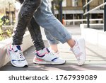 Close up of feet. Couple wearing sneakers in embrace.