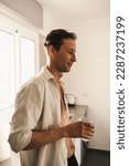 Small photo of Portrait of attractive male slob drinking whiskey in his kitchen