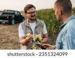 Small photo of Farmer is holding a corn crop and shoving it to investor.