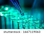 Small photo of Pipette adding fluid to one of several test tubes, medical abstract background.