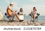 Small photo of Happy friend have fun playing guitar and clap in camp they smiling together in holiday on sand beach near camping tent vacation time at sunset, Young Asian group woman and man in summer travel outdoor