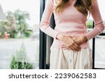 Small photo of Asian young female unhappy unwell sick ill hand holding on stomach suffers pain at home, Sad Woman Stomach Ache from menstruation, Abdomen bloating and Chronic gastritis concept