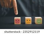 Small photo of Unhappy customer expressing dissatisfaction with sad emoticon on wooden block. Concept of customer experience dissatisfaction, bad review and low rating. unsatisfied customers on business reputation.