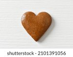 Gingerbread heart on a white background with a wood texture, can be used as a greeting card for Valentine's Day