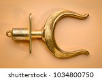 Small photo of brass rowlocks (oarlock) on beige background