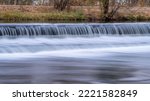 Water cascading over a diversion dam on the Poudre River with fall scenery, nature and industry concept