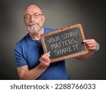 your story matters, share it - white chalk writing on a retro blackboard held by a senior man, presenter, teacher or mentor