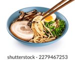Ramen soup with noodles, leek, nori, shiitake mushroom, soft egg and chashu pork on white background. Chopsticks hold noodles.