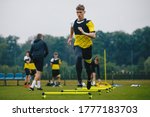 Small photo of Teenager Boy Soccer Player in Training. Young Soccer Players at Practice Session with Coach. Footballer Jumping Over Hurdles. Boys Running Youth Agility Ladder Drills. Soccer Ladder Exercises