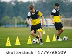 Small photo of Boys on soccer football training. Young players dribble ball between training cones. Players on football practice session. Soccer summer training camp