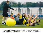 Small photo of Soccer Players: Stretching Session With Physiotherapist. Youth Sports Team On Recovery Session After League Match. Football Players Warming Up on Grass Stadium Field