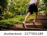 Small photo of Athlete's sinewy legs on the steps