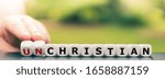 Small photo of Hand turns dice and changes the word "unchristian" to "christian".