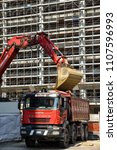 Small photo of Milan,Italy - May 24 2018: Modern excavator performs excavation work and dumber truck, industrial machinery on building site.