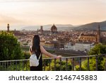 Young woman tourist watching Florence and Cathedral of Santa Maria Del Fiore. Vacation concept with view of Firenze, Italy from Piazzale Michelangelo.
