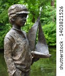 Small photo of TICEHURST, EAST SUSSEX, ENGLAND - MAY 18, 2019: Statue of Boy with pond yacht Pashley Manor Gardens.