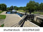 Houghton Lock on the River Ouse in Cambridgeshire with small boat moord on a sunny day.