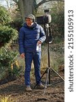 Small photo of LODE, CAMBRIDGESHIRE, ENGLAND - FEBRUARY 11, 2022: BBC Sound recordist on location in a garden in winter.