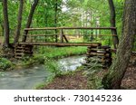 Beautiful blue river. A wooden bridge over the river in a beautiful green forest scenery.
