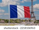 Flag of France waving in the wind. French flag on sunny blue sky background on a white flag pole